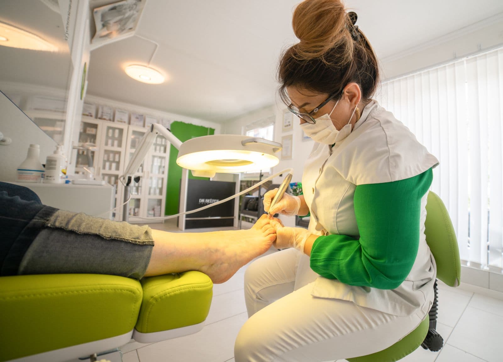 Une pédicure-podologue en train de soigner un patient dans son cabinet
